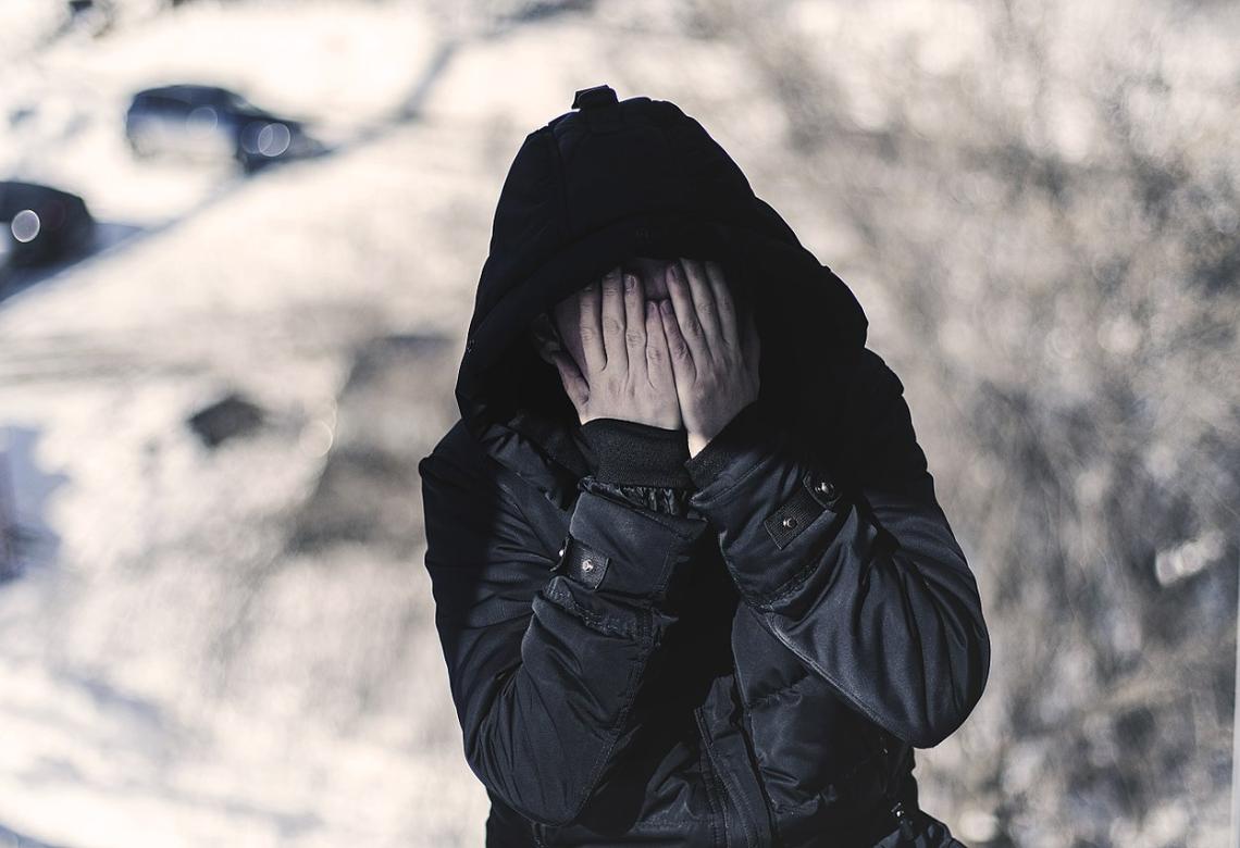 Depression - a lonely alcoholic in fear covers his face with his hands